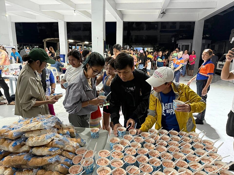 Volunteers distributing hot meals to evacuees at a community kitchen in the Philippines