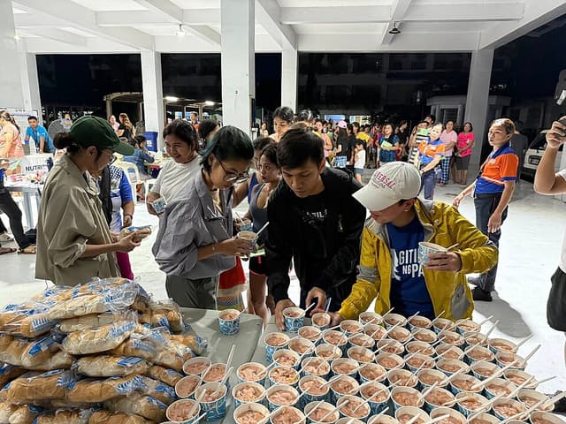 Volunteers distributing hot meals to evacuees at a community kitchen in the Philippines