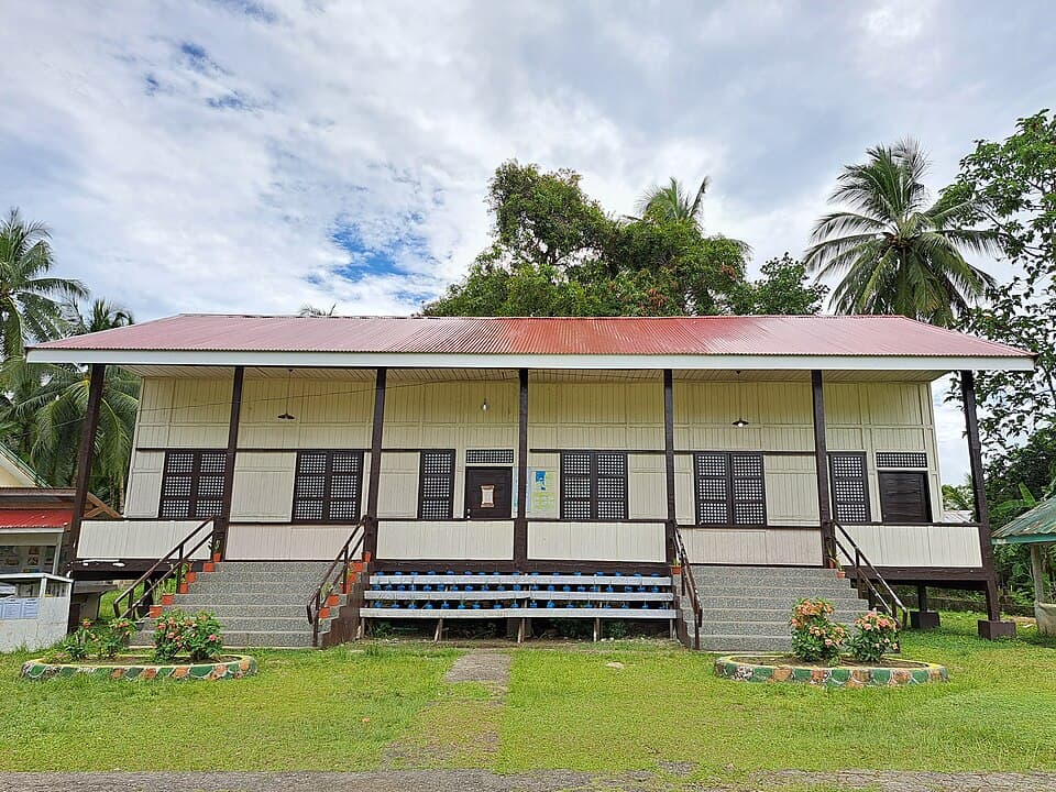 A restored wooden Gabaldon-style school building with a red roof at Arorogan Elementary School in Marihatag, Surigao del Sur