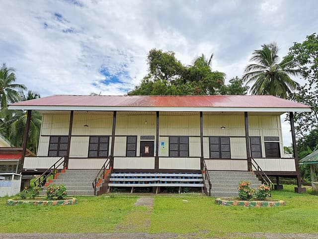 A restored wooden Gabaldon-style school building with a red roof at Arorogan Elementary School in Marihatag, Surigao del Sur